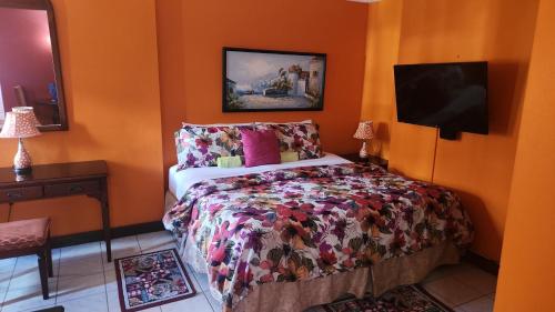 1 dormitorio con 1 cama y TV de pantalla plana en Turtle Towers, en Ocho Ríos