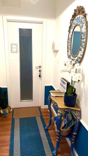 a hallway with a table and a mirror and a door at Marcel Zadar Old Town in Zadar
