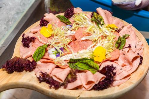 a pizza with meat and vegetables on a cutting board at Shanghai Haichang Ocean Park Resort Hotel in Shanghai