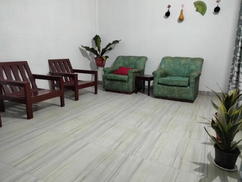 um quarto com 2 cadeiras e uma mesa com uma almofada vermelha em Moa's Nest em Dimāpur