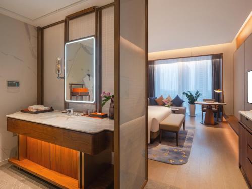 a bathroom with a sink and a living room at Suzhou International Conference Hotel in Suzhou