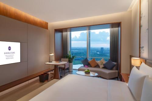 ein Hotelzimmer mit einem Bett und einem Sofa in der Unterkunft Suzhou International Conference Hotel in Suzhou