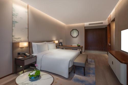a hotel room with a bed and a desk at Suzhou International Conference Hotel in Suzhou