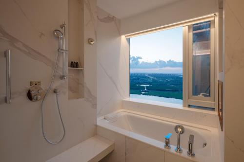 a bathroom with a shower and a tub and a window at Suzhou International Conference Hotel in Suzhou