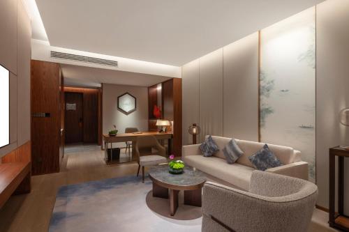 a living room with a couch and a table at Suzhou International Conference Hotel in Suzhou