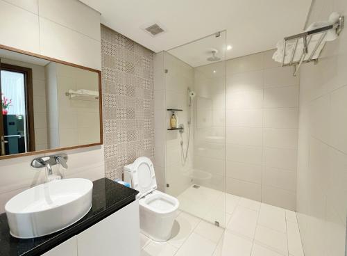 Baño blanco con lavabo y aseo en The Stunning Home - Apec Mandala Phú Yên, en Tuy Hoa