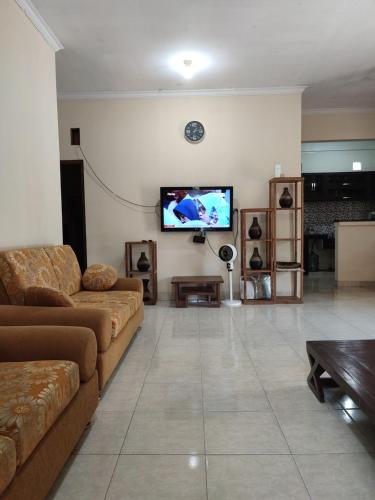 een woonkamer met een bank en een flatscreen-tv bij Emir Homestay in Timuran