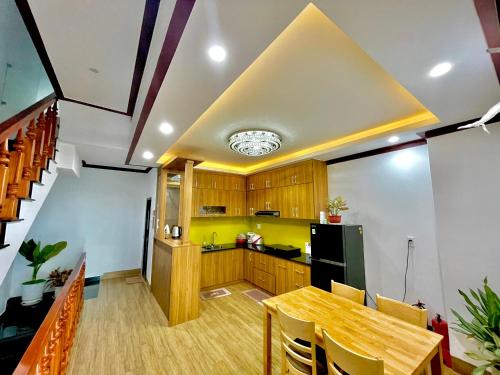 cocina con mesa de madera y pared amarilla en KHÁCH SẠN HỒ GIA VILLA Phan Rang, en Kinh Dinh