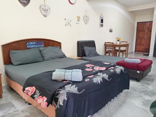 a bedroom with two beds and a table at D'Mentari Ocean View Resort Studio in Kampong Tanah Merah