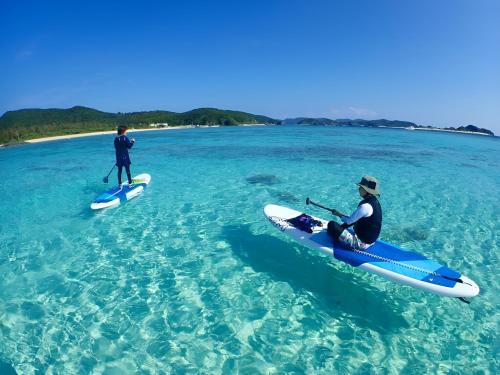 dos personas están sentadas en sus kayaks en el agua en AVAHOUSE アバハウス en Isla Miyako