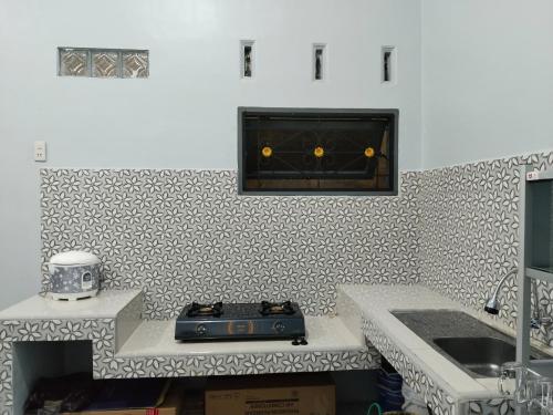a kitchen with a stove and a counter top at Rome Residence Sibolga Pandan in Halangan
