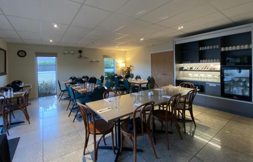 une salle à manger avec des tables et des chaises ainsi qu'un bar dans l'établissement Saxton Lodge Motel, à Nelson