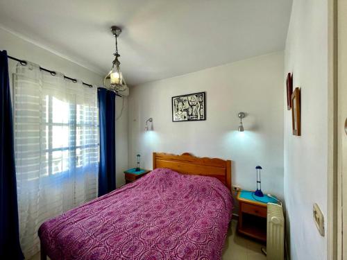 een slaapkamer met een bed met een paarse deken bij Le 5éme Penthouse cosy with sea view in Sousse