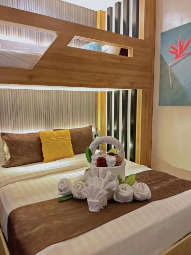 a bed with a tray of towels and dishes on it at Aloha Boracay Hotel in Boracay