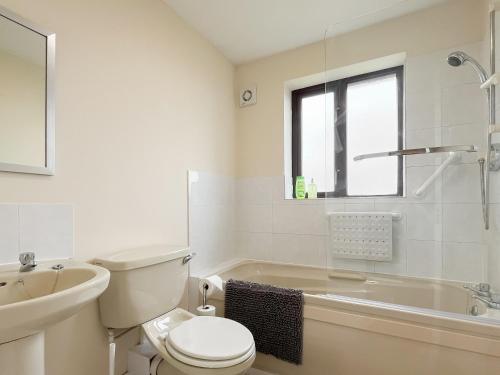 a white bathroom with a toilet and a sink at Rosings in Bradfield