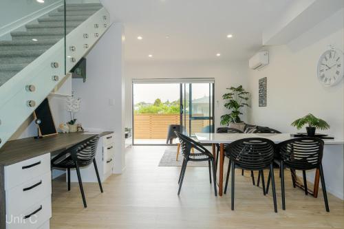 cocina y comedor con mesa y sillas en Modern Howick Town House Fibre WiFi Netflix, en Auckland