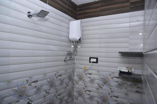 uma casa de banho com um chuveiro com peixes na parede em Hotel Solis Stay em Solapur