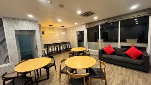 a room with tables and chairs and a couch at PHP BOUTIQUE TOWNHOUSE in Chennai