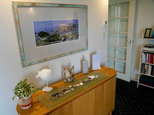 3 Waters Guest Accommodation في غولد كوست: غرفة مع خزانة خشبية مع صورة على الحائط