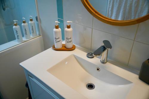 3 Waters Guest Accommodation في غولد كوست: حمام مع حوض ومرآة