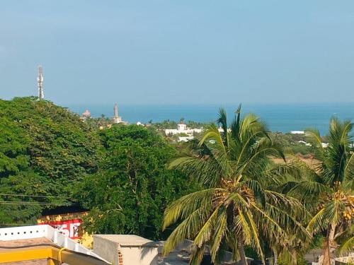 a view of the ocean and palm trees at HOTEL AATHANAM in Kanyakumari