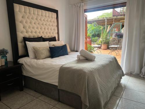 una camera con un grande letto e una grande finestra di Map's View Guesthouse a Johannesburg