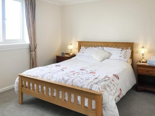 a bedroom with a large white bed with two lamps at Sea Drift in Walcott