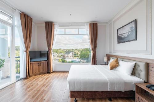 um quarto com uma cama e uma grande janela em PINE VIEW Hotel Dalat em Da Lat