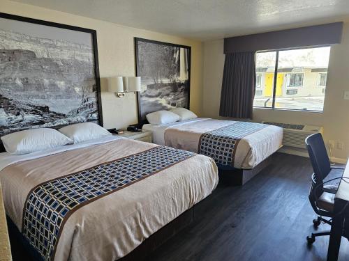 Habitación de hotel con 2 camas y ventana en Canyon Inn Flagstaff, en Flagstaff