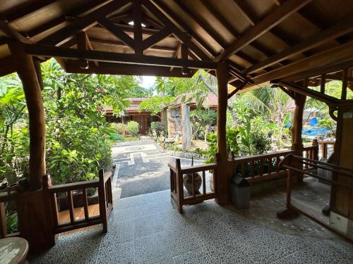 an entrance to a garden with a wooden pavilion at Sunny Rose Bungalows Gili Air in Gili Islands