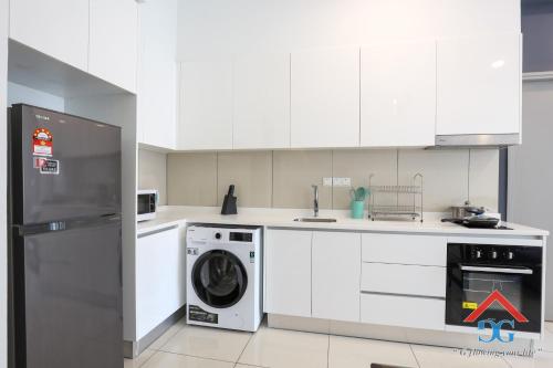 a kitchen with white cabinets and a washer and dryer at Astoria Ampang By Grabstay in Kuala Lumpur