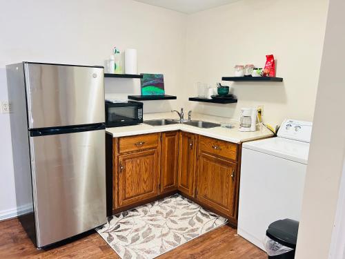 uma cozinha com um frigorífico de aço inoxidável e armários de madeira em Basement unit with 2 bedrooms, bath and living area em Lower Sackville