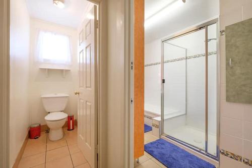 a bathroom with a toilet and a walk in shower at Your Home at Southside Central - Family friendly. in Bundaberg