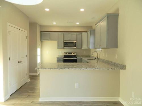 cocina con armarios blancos y encimera en Entire home in Statesville, NC en Statesville