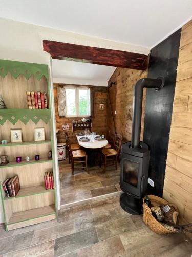 a wood stove in a room with a table at Gîte Les papillons 4 étoiles in Gondrin