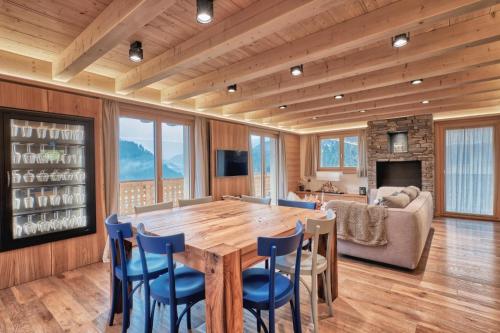 una sala da pranzo con un grande tavolo in legno e sedie di Chalet Capucchione a Les Diablerets