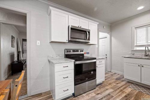 a kitchen with a stove and a microwave at Entire Tiny House with Large Yard Fenced In! in West Valley City