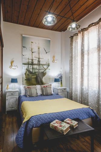 a bedroom with a bed and a painting of a ship at Sagredo Traditional House in Nafplio