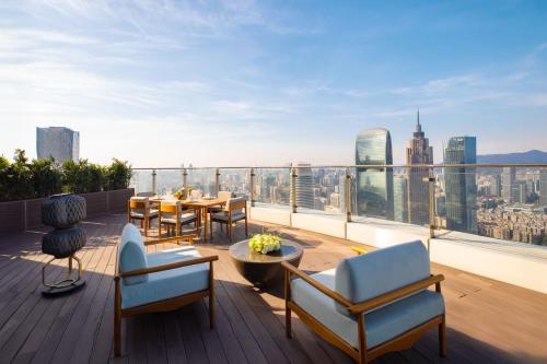a balcony with a table and chairs and a view of the city at Jumeirah Guangzhou - Complimentary Shuttle Bus to Canton Fair Complex in Guangzhou