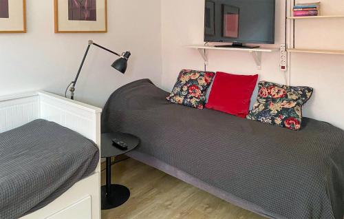 1 dormitorio pequeño con 1 cama y TV en Cozy Apartment In Frjestaden With Wifi, en Färjestaden
