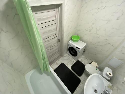 a bathroom with a tub and a toilet and a sink at Sati Club House in Prigorodnyy