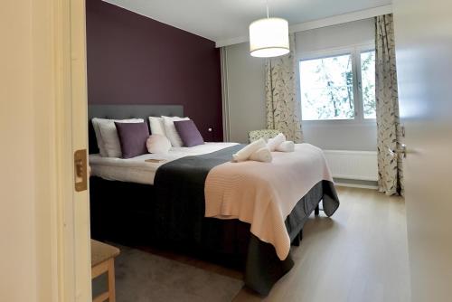 a bedroom with a bed with purple walls and a window at Spacious Haven near Mall and Convention Center in Helsinki