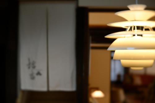 a group of lights hanging from a ceiling at Kyoto Fushimi Sutekichi Private Hotel in Fushimi