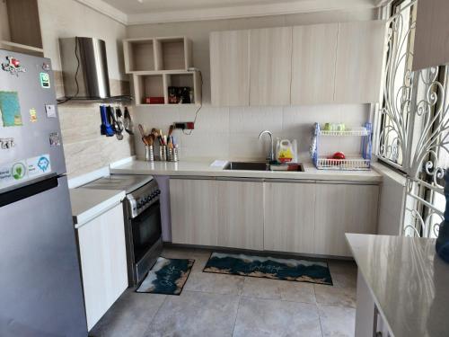 uma cozinha com um lavatório e um frigorífico em Vesta Garden Apartment em Nairobi