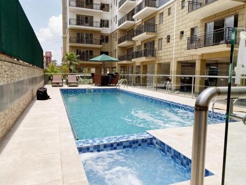 a swimming pool in front of a building at Vesta Garden Apartment in Nairobi