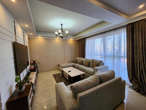 uma sala de estar com um sofá e uma mesa em Vesta Garden Apartment em Nairobi