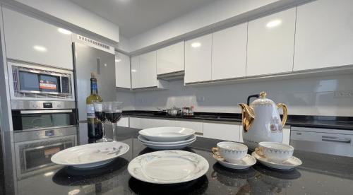 a kitchen with white cabinets and four dishes on a counter at Rare find! Skyline view-Modern 6 bed 2 bath flat in the heart of Málaga in Málaga