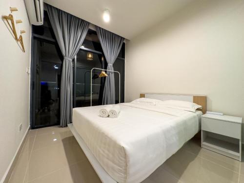 a bedroom with a large white bed and a window at Downtown Remin Suites at The Shore Kota Kinabalu in Kota Kinabalu
