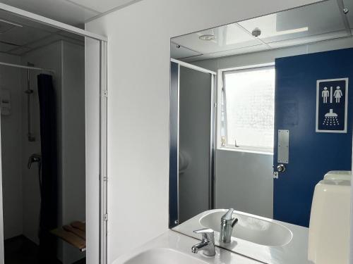 uma casa de banho com um lavatório e um espelho em United Auckland em Auckland