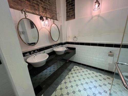 a bathroom with two sinks and two mirrors at THE GARDEN SUITE in Balik Pulau